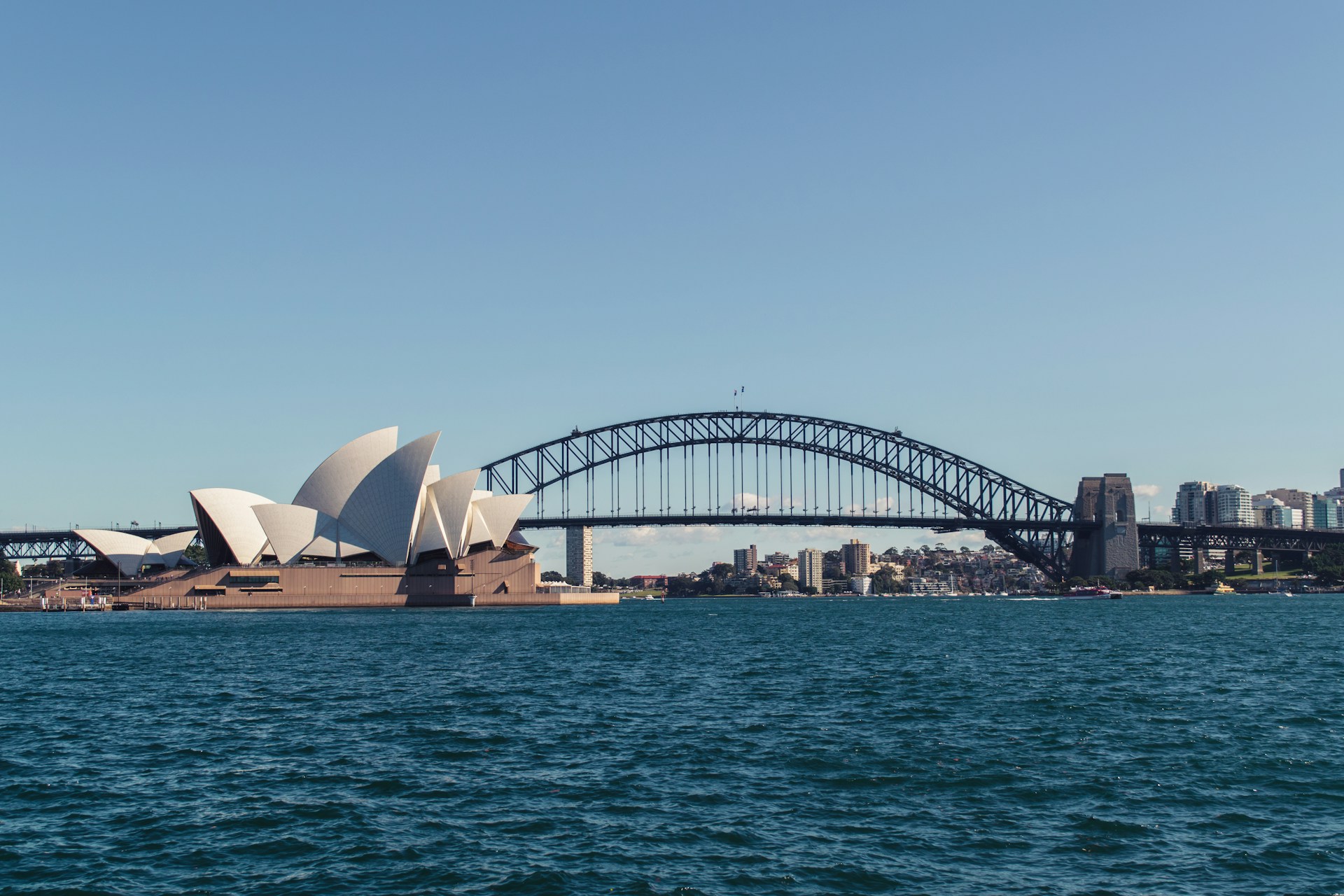 Sydney Opera House and Harbour Bridge viewed from the water, showcasing iconic landmarks in Sydney, Australia.